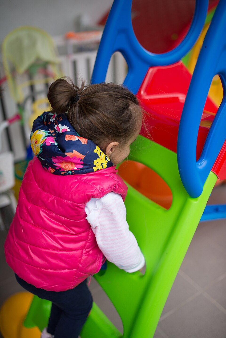 Jeune enfant grimpant sur une structure de jeux colorée